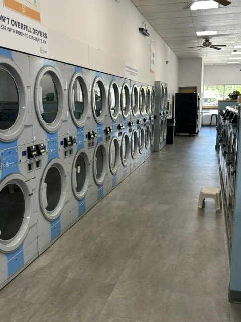 A long row of clean, high-capacity stacked machines at Scrubs Laundry in Chelsea